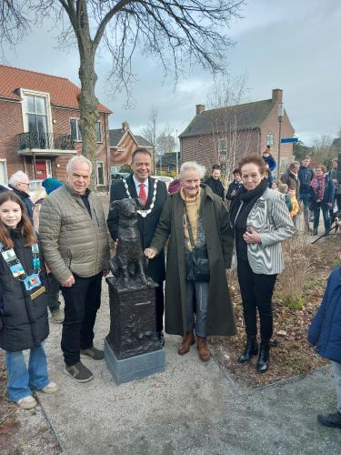 burgemeester poseert bij beeldje met de initiatiefnemers en kinderburgemeester.